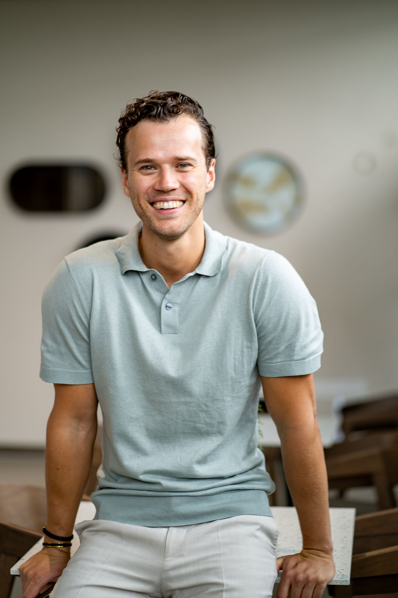 Gideon zittend Man, zittend op een tafel en lacht.